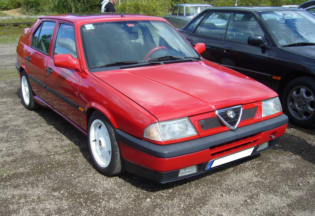 Alfa Romeo 33 1.7 IE 16V. Die Baureihe 33 (Werksintern 905/907) kam 1983 als Nachfolger des Alfasud auf den Markt. Im Frühjahr 1990 erschien dann ein optisch und technisch modifizierter Alfa Romeo 33. Mit diesem Facelift kam dann der gezeigte 1.7 IE 16V auf den Markt. Äußerlich erkennbar am roten Ring um den Kühlergrill. Der Vierzylinderboxermotor hat einen Hubraum von 1712 cm³ und leistet 137 PS. Das Werk gab die Höchstgeschwindigkeit seinerzeit mit 207 km/h an. Das Modell war auch als Kombi lieferbar. 10. Oldtimertreffen des AMC Duisburg am 25.08.2024 am LaPaDu Duisburg.