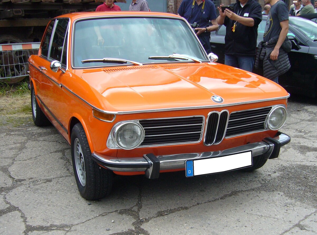 BMW 2002, produziert von 1968 bis 1975. Hier wurde ein 2002 abgelichtet, der zwischen April 1971 und September 1973 produziert wurde, da er schon die seitlichen Gummizierleisten trägt, aber noch mit den runden Heckleuchten ausgestattet ist. Das Fahrzeug ist im Farbton inkaorange lackiert. Der Vierzylinderreihenmotor leistet 100 PS aus einem Hubraum von 1.990 cm³. 16. Oldtimer-Festival an der  Alten Dreherei  in Mülheim an der Ruhr am 16.06.2024.