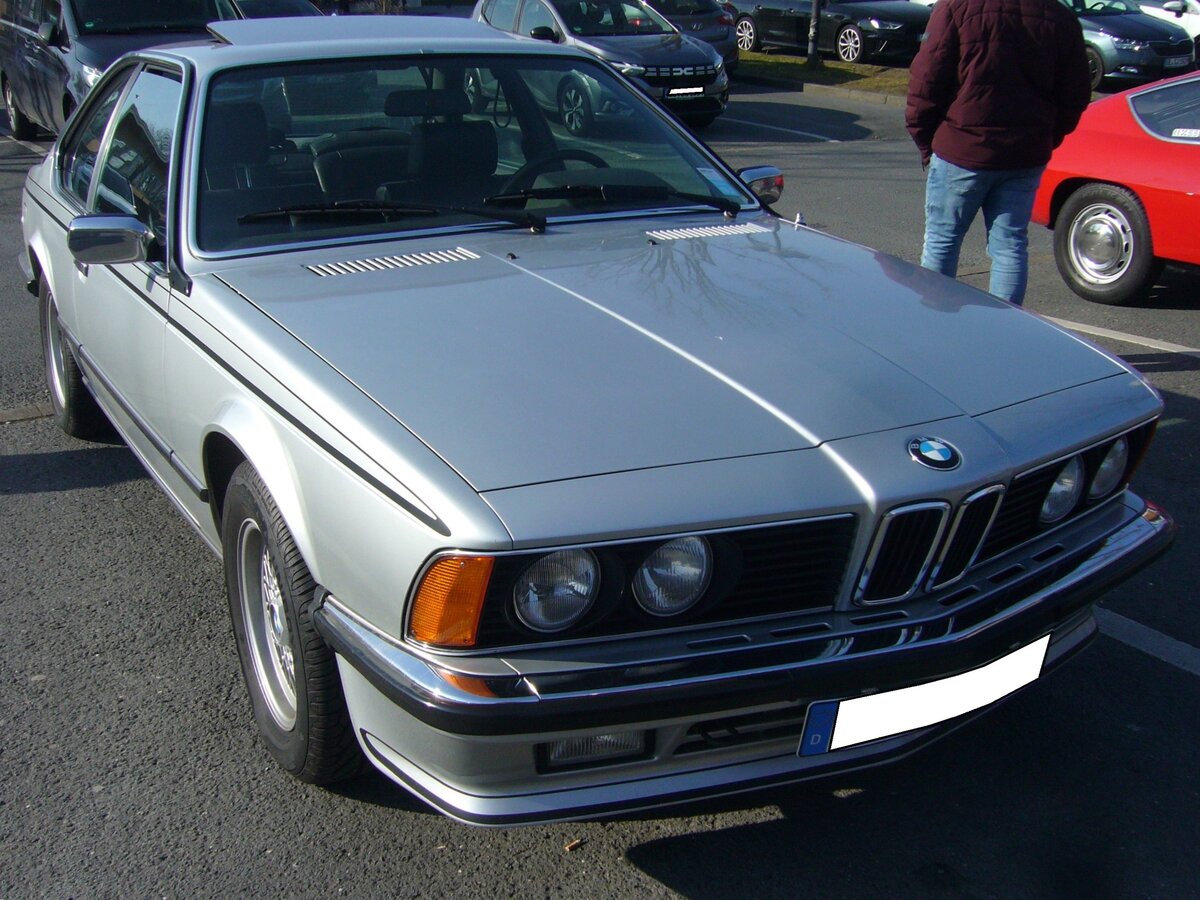 BMW E24 635 CSi, gebaut in den Jahren von 1978 bis 1987. Der abgelichtete E24 ist im Farbton polarissilbermetallic lackiert. Der, mit einer rechtsseitigen Neigung von 30 Grad, verbaute Sechszylinderreihenmotor hat einen Hubraum von 3453 cm³ und leistet 218 PS. Die Höchstgeschwindigkeit wurde vom Werk mit 225 Km/h und der Verbrauch mit 15 Liter Superbenzin auf 100 Kilometer angegeben. Oldtimerbrunch am Cafe del sol in Gelsenkirchen am 09.03.2025.