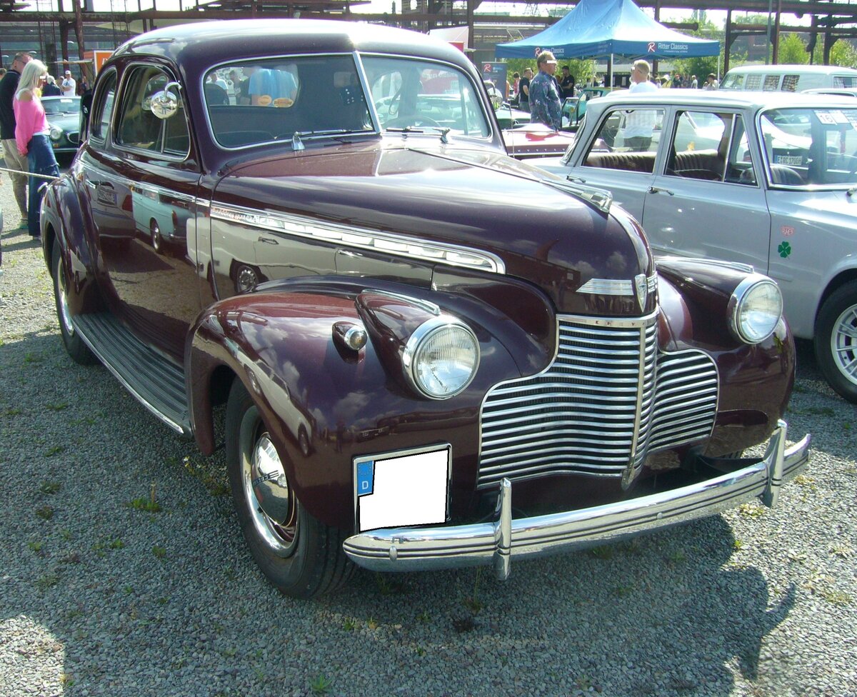 Chevrolet Master DeLuxe KH-Six Business Coupe aus dem Jahr 1940. Die so genannten  Business Coupes  waren in den 1930´er und 1940´er Jahren sehr beliebte Flottenfahrzeuge in den USA. So ziemlich jeder Autohersteller hatte ein solches Modell im Programm. Ganze Generationen von Handelsvertretern kreuzten mit diesen Fahrzeugen durch die Vereinigten Staaten und boten ihr Warensortiment an. Die Sitze konnten in der Regel zu einer Liegefläche umgelegt werden und der Kofferraum war vom Fahrzeuginneren zugänglich, das der Vertreter auch im Fahrzeug übernachten konnte. Ein solches Coupe der Marke Chevrolet kostete im Jahr 1940 genau US$ 659,00. Der Sechszylinderreihenmotor hat einen Hubraum von 3550 cm³ und leistet 85 PS. Oldtimer-Revival auf dem Gelände der Kokerei Zollverein in Essen am 28.07.2024.