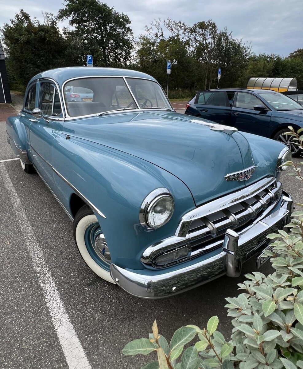 Chevrolet Series 2100KK Styleline DeLuxe fourdoor Sedan aus dem Jahr 1952. Für eine solche, viertürige, Limousine musste man in diesem Modelljahr mindestens US$ 1749,00 anlegen. 1952 entschieden sich 319.736 Käufer/innen für ein solches Modell in dieser Karosserie- und Ausstattungsvariante. Der Chevy im Farbton twilight blue wird von einem Sechszylinderreihenmotor angetrieben, der aus einem Hubraum von 3546 cm³ 90 PS leistet. Westkapelle/Niederlande am 04.09.2024.