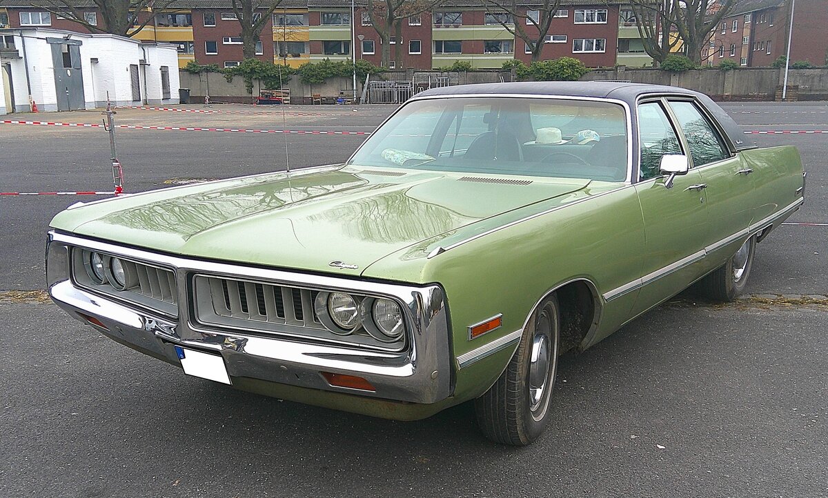 Chrysler Newport Custom Sedan aus dem Modelljahr 1972. Im Jahr 1972 war die Newport-Baureihe das Basismodell in der Modellpalette der Chrysler Corp.. Darüber rangierte die Baureihe New Yorker und das Toppmodell war der Three Hundred. Für eine solche, viertürige Limousine, musste man mindestens US$ 4630,00 auf den Tresen des Chrysler-Dealers legen. Der gezeigte Newport custom Sedan dürfte im Farbton mist green lackiert sein. Der Kunde hatte die Wahl zwischen drei verschiedenen V8-Motoren: 360 cui (5899 cm³) mit 175 PS, 400 cui (6555 cm³) mit 190 PS und 440 cui (7210 cm³) mit 225 PS. Oldtimertreffen an Mo´s Bikertreff in Krefeld am 09.02.2025.