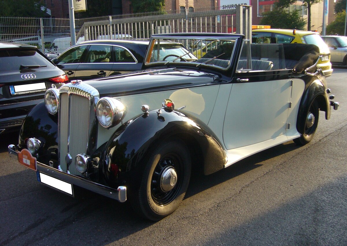 Daimler DB18 DHC aus dem Jahr 1940. Das Modell DB18, auch 2,5 Litre genannt, erschien im Jahr 1939. Kriegsbedingt wurde die Produktion 1940 eingestellt. Nach WW2 wurde die Produktion, mit kleineren Modifikationen, wieder aufgenommen. Der Wagen war als fourdoor Saloon und als D rop H ead C oupe (wie auf dem Foto) mit Karosserien von Barker/London und Hooper/Westminster lieferbar. Der Sechszylinderreihenmotor hat einen Hubraum von 2522 cm³ und leistet 71 PS. 11. Saarner Oldtimer Cup am 01.09.2024 in Mülheim an der Ruhr-Saarn.