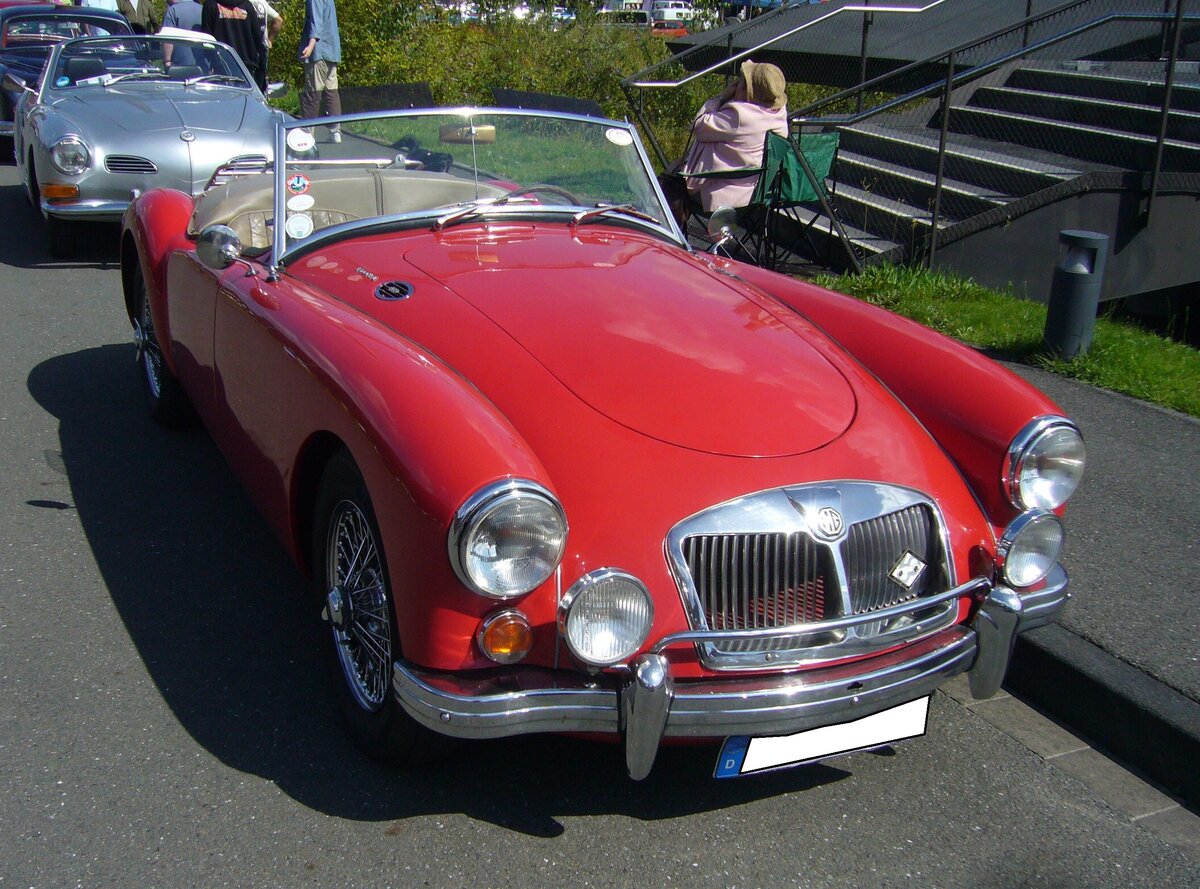 Der MG A kam 1955 auf den Markt und war als Roadster und geschlossenes Coupe lieferbar. Von den über 101.000 hergestellten Autos vom Typ MG A waren ca. 91% Roadster und nur 9% Coupes. Der gezeigte MG A 1600 MK2 kam 1961 auf den Markt. Er war optisch durch einen leicht geänderten Kühlergrill und die Heckleuchten des Morris Mini, die horizontal unterhalb der Kofferraumhaube verbaut waren, zu erkennen. Der Vierzylinderreihenmotor war in der MK2-Version nochmals auf einen Hubraum von 1622 cm³ aufgebohrt worden. und leistete nun 94 PS. Oldtimer-Revival auf dem Gelände der Kokerei Zollverein in Essen am 28.07.2024.