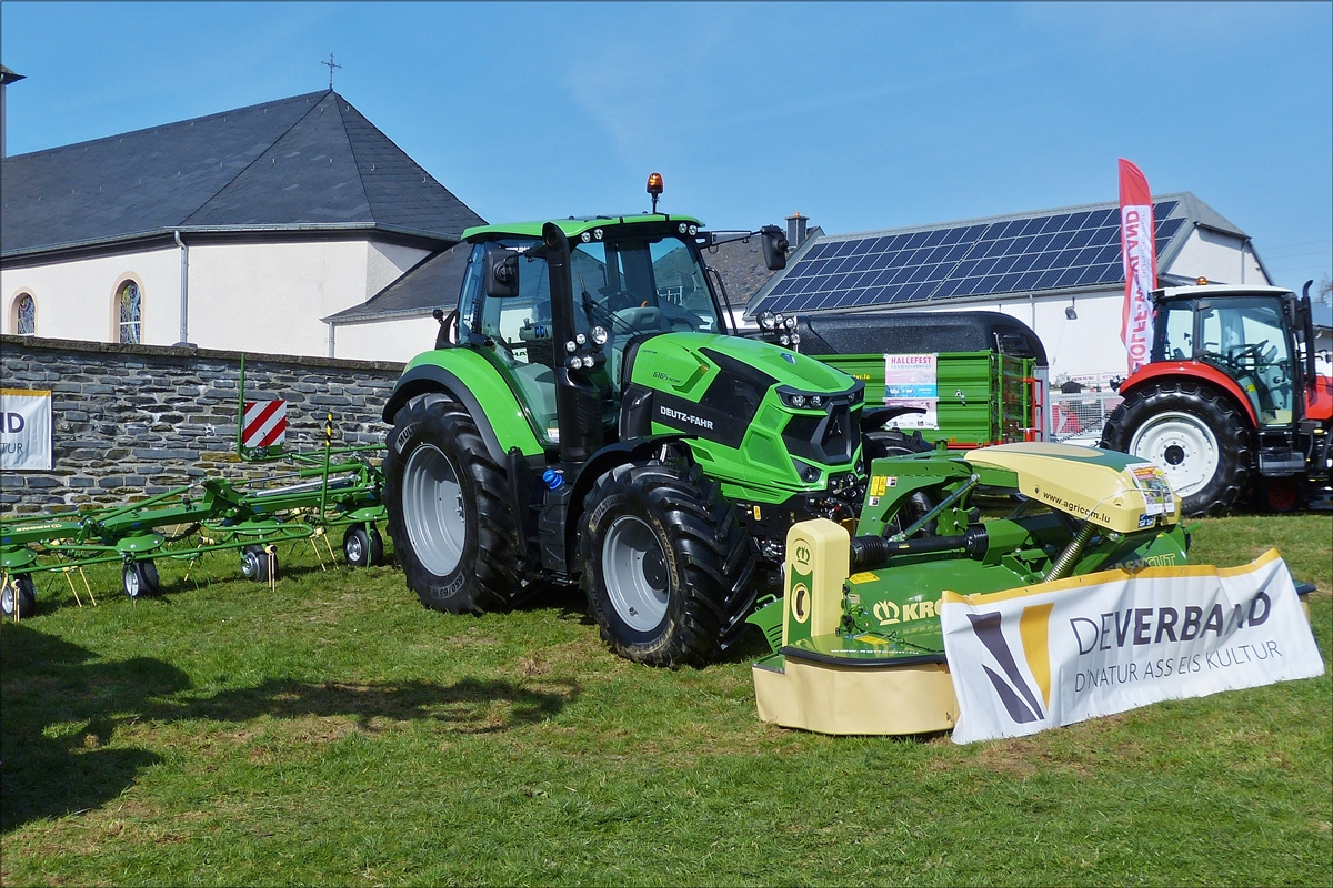  Deutz - Fahr 6165 mit angehängtem Krone Mähwerk an der traktorfront, ausgestellt beim Bauerntag in Brachtenbach. 26.03.2017