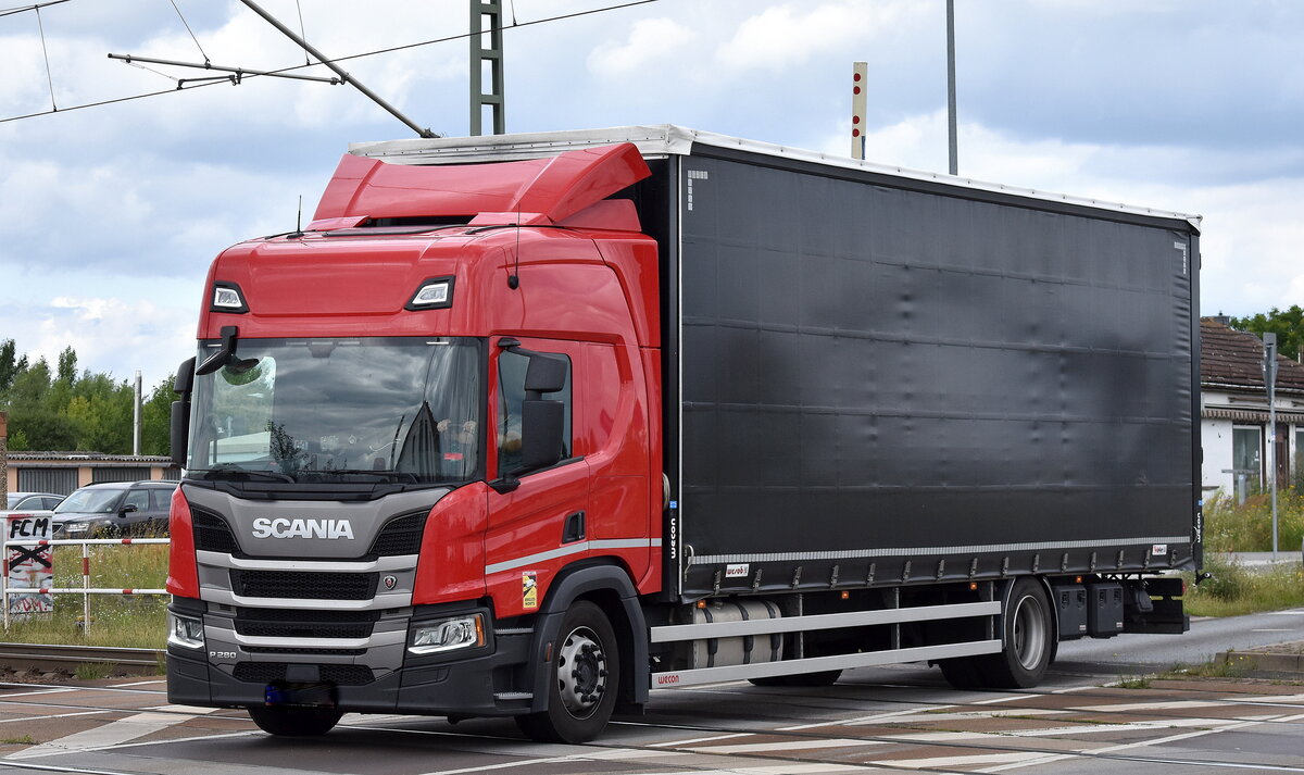 Ein polnischer SCANIA P 280 LKW mit Pritschenaufbau mit Plane am 17.07.24 Bahnübergang Rodleben.