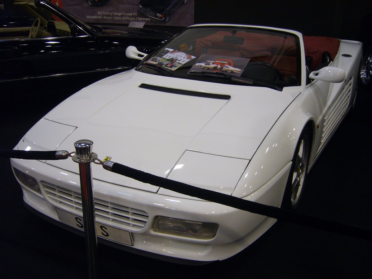 Ferrari 512  Testarossa  im Farbton bianco. Produziert wurde der  Rotschopf  in den Jahren von 1984 bis 1994. Das Modell erhielt diese Zusatzbezeichnung aufgrund der rot lackierten Zylinderköpfe. Der Umbau zum Roadster mit einem elektrohydraulischen Verdeck erfolgte im Jahr 1995 bei der SGS (S tyling G arage S tuttgart). Der  Testarossa  hat einen V12-Motor mit einem Hubraum von 4943 cm³ der 390 PS leistet. Essen Motor Show am 04.12.2024.