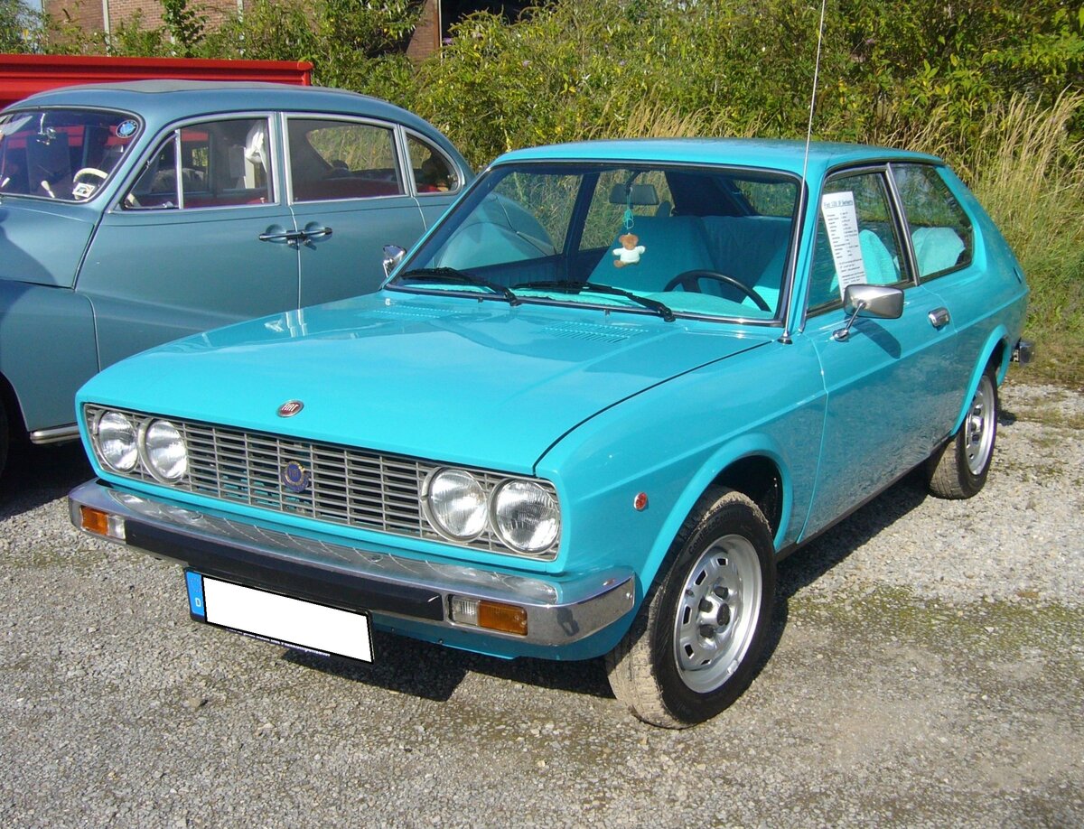 Fiat 128 3P Berlinetta (das 3P steht übrigens für tre porte = drei Türen) aus dem Jahr 1976. Produziert wurde das Coupe-Modell von 1975 bis 1979. Der abgelichtete 128 P3 Berlinetta ist mit dem größeren, damals lieferbaren Motor bestellt worden. Dieser Vierzylinderreihenmotor leistet 73 PS aus einem Hubraum von 1290 cm³ Hubraum. Dieses schicke Coupe ist im Farbton Adriablau lackiert. Zum Jahresende 2015 waren von diesem Modell noch 44 Fahrzeuge in Deutschland angemeldet. Um sich damals ein solches Auto kaufen zu können, musste man mindestens DM 11.300,00 auf die Theke des Fiat-Händlers legen. 10. Oldtimertreffen des AMC Duisburg am 25.08.2024 am LaPaDu Duisburg.