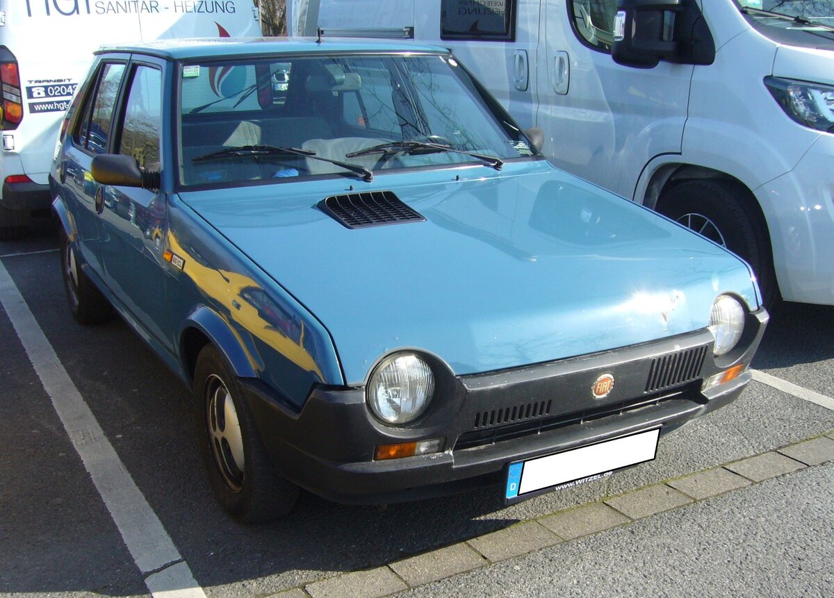 Fiat Ritmo 60CL im Farbton tahiti blau. Der mit einer praktischen Heckklappe versehene Ritmo war ab Oktober 1978 in Deutschland lieferbar. Der Nachfolger des populären Fiat 128 folgte dem Rezept vom VW Golf. Charakteristisch allerdings waren die großflächigen vorderen und hinteren Stoßfänger. Die Rücksitzbank konnte ganz vor geklappt werden. Bei den besser ausgestatteten CL-Modellen (Foto) sogar geteilt. Das Modell konnte drei- oder fünftüriges bestellt werden. Der Ritmo 60 war der Ritmo mit der kleinsten Motorisierung. Der Vierzylinderreihenmotor hat einen Hubraum von 1116 cm³ und leistet, wie es die Typenbezeichnung schon erkennen lässt, 60 PS. Die Höchstgeschwindigkeit gab man in Turin mit 145 km/h an. Oldtimerbrunch am Cafe del sol in Gelsenkirchen am 09.03.2025.