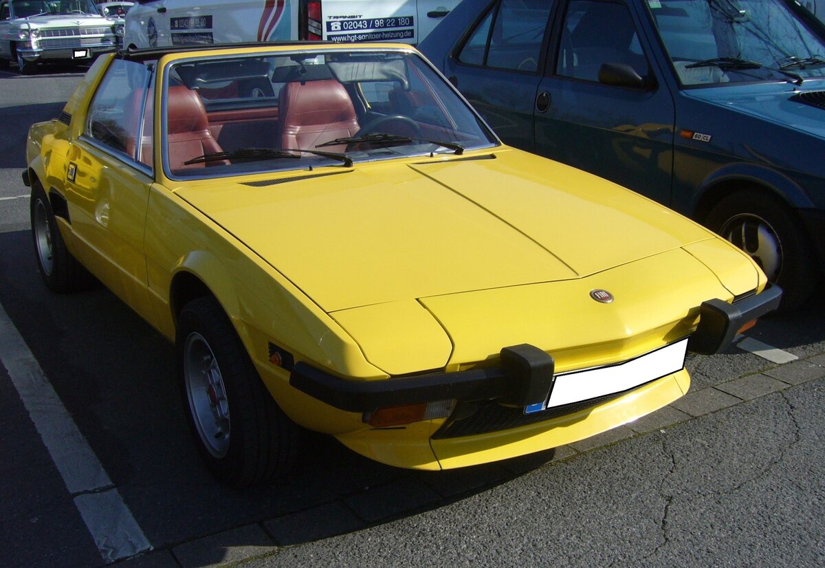 Fiat X 1/9, produziert von 1972 bis 1988. Das Modell X 1/9 basierte auf der Plattform des Fiat 128, war aber mit einem Mittelmotor bestückt. Hier wurde ein X 1/9 der ersten, auch A Serie genannt, abgelichtet. Der quer eingebaute Vierzylinderreihenmotor hat einen Hubraum von 1290 cm³ und leistete in den Jahren von 1972 bis 1974 75 PS. In den Jahren von 1974 bis 1978 noch 73 PS. Oldtimerbrunch am Cafe del sol in Gelsenkirchen am 09.03.2025.