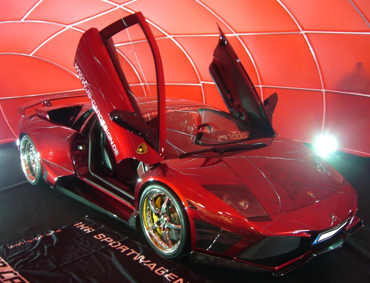 Lamborghini Murcielago Coupe, gebaut von 2001 bis 2010. Der, unter der Regie von Audi entwickelte, Murcielago war als Coupe und Roadster erhältlich. Ab dem Jahr 2006 konnte dann der hier gezeigte, modifizierte, Murcielago LP640 bestellt werden. Der als Mittelmotor verbaute V12-Motor leistet serienmäßig 640 PS aus aus einem Hubraum von 6498 cm³. Der gezeigte LP640 ist allerdings technisch modifiziert worden und leistet 750 PS. Der mit einem permanenten Allradantrieb ausgerüstete Sportwagen erreicht damit eine Höchstgeschwindigkeit von ca. 330 km/h. Insgesamt verließen rund 4100 Fahrzeuge die Bänder in Sant Agata Bolognese. Essen Motor Show am 04.12.2024.