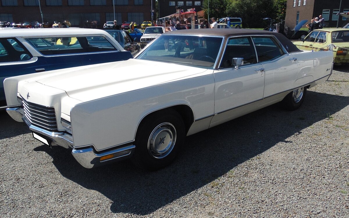 Lincoln Continental Sedan aus dem Jahr 1971. Die 1971´er Modelle der Ford-Luxusdivision Lincoln wurden am 18. September 1970 offiziell vorgestellt. Kurz danach begann die Auslieferung des als Coupe und Limousine lieferbaren Modelles. Die Limousine war als Hardtop und Sedan (Foto) lieferbar. Von der Hardtop Limousine wurden in diesem Modelljahr 8205 und vom Sedan 27.346 Fahrzeuge zu einem Preis ab US$ 7016,00 verkauft. Für Vortrieb sorgt in dieser luxuriös ausgestatteten Limousine ein V8-Motor mit einem Hubraum von 460 cui (7538 cm³) und einer Leistung von rund 370 PS. Die Verbrauchsangaben schwanken zwischen 18 und 23 Litern Benzin auf 100 Kilometer. Oldtimer-Revival auf dem Gelände der Kokerei Zollverein in Essen am 28.07.2024.