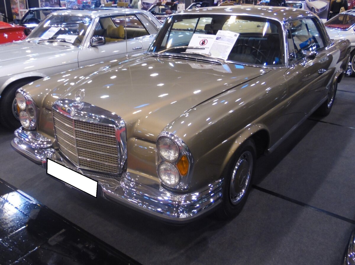 Mercedes Benz W111 280SE 3.5 Coupe. Im Jahr 1967 brachte Mercedes-Benz einen neuen 2,8-l-Motor heraus. Demzufolge hieß das W111 Coupe nun 280 SE Coupé. Ein weiteres, auch äußerlich erkennbares Facelift, gab es bei den W111 Modellen ab dem Jahr 1969 mit der Einführung eines V8-Motors mit einem Hubraum von 3499 cm³ und einer Leistung von 200 PS. Die Frontpartie erhielt mit diesem Modell eine flachere Motorhaube und einen niedrigeren Kühlergrill. Die Modelle hießen ab diesem Zeitpunkt in der Szene  Flachkühler“. Die Höchstgeschwindigkeit gab man bei Mercedes Benz mit 210 km/h an. Dann wurden aber auch bis zu 18,5 Liter Superbenzin mittels der elektronisch gesteuerten Bosch-Einspritzpumpe in die Brennräume eingespritzt. Essen Motor Show am 04.12.2024.