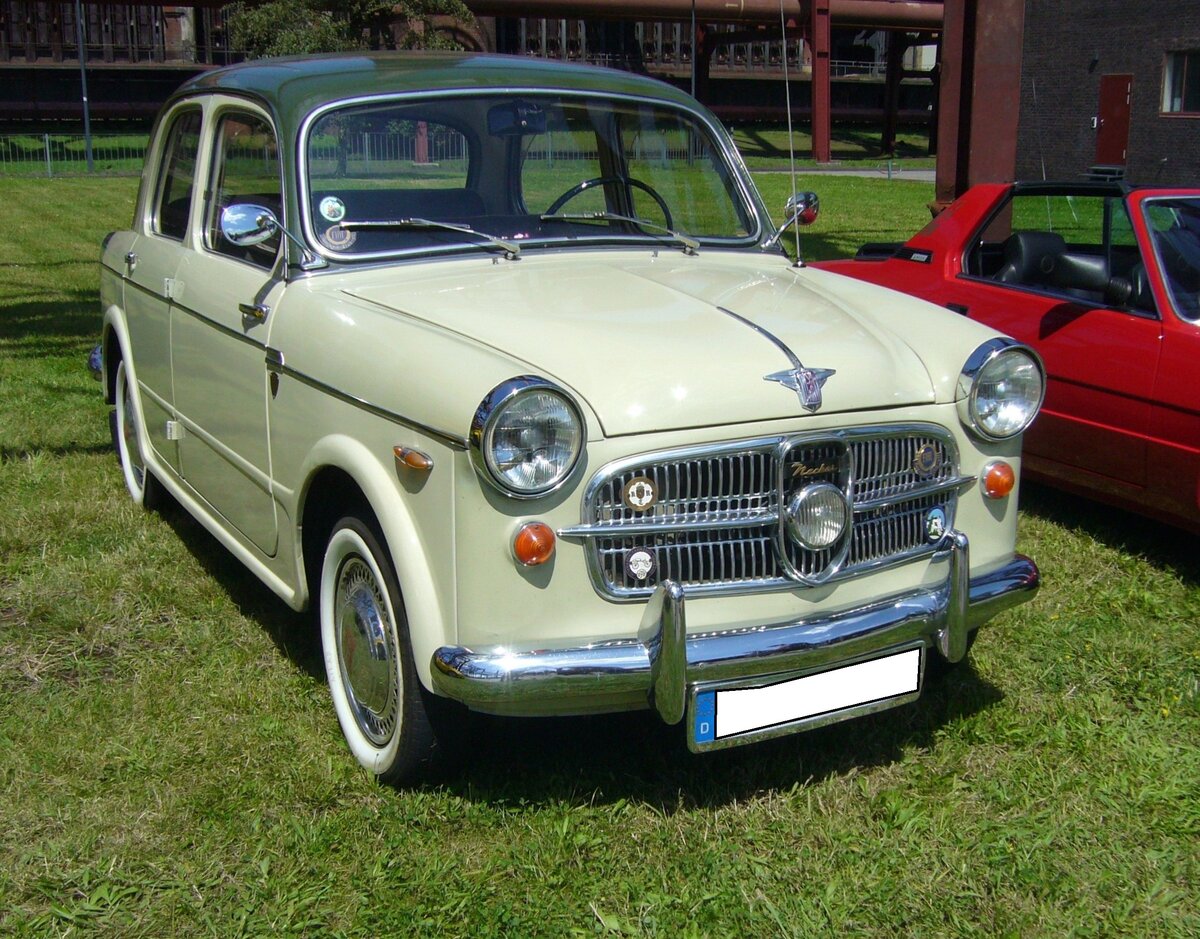 NSU-Fiat Neckar 1100 103D, der Modelljahre 1958 und 1959. Fiat hatte bereits 1929 in Heilbronn am Neckar ein NSU Montagewerk übernommen. Daher hießen sämtliche, dort für den deutschen Markt produzierten Autos, NSU-Fiat  Neckar . Das abgelichtete Fahrzeug war in dieser Karosserievariante nur zwei Jahre im Programm. Der Motor leistete 40 PS aus einem Hubraum von 1.089 cm³. Ein solcher, viertüriger, Wagen schlug 1958 mit einem Kaufpreis von mindestens DM 5.700,00 zu Buche. Die Modelle dieser beiden Baujahre waren serienmäßig immer zweifarbig lackiert. Das markanteste Merkmal ist allerdings der einzelne Nebelscheinwerfer im Kühlergrill. Oldtimer-Revival auf dem Gelände der Kokerei Zollverein in Essen am 28.07.2024.