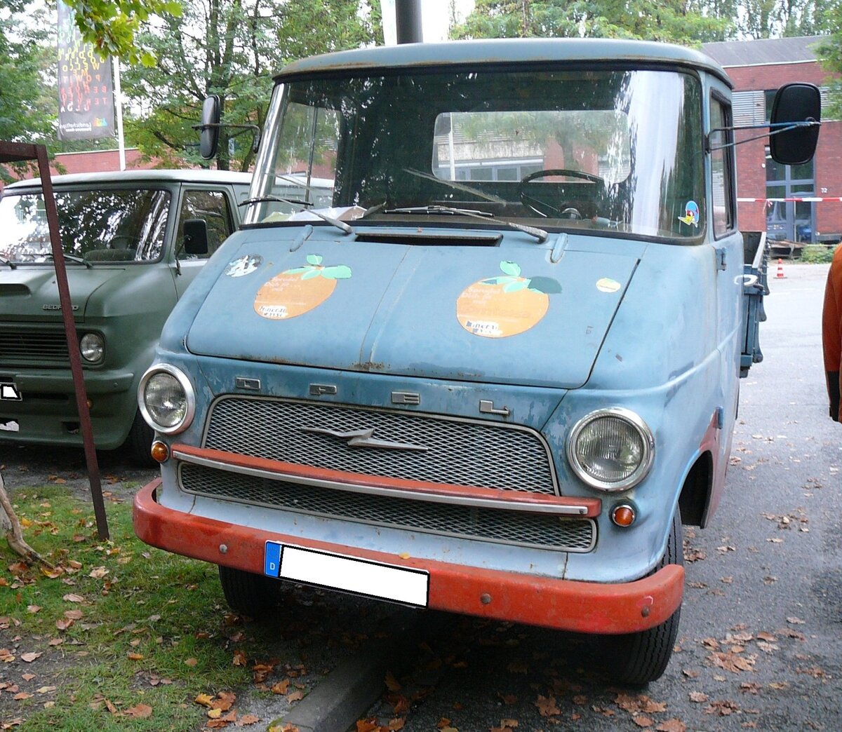 Opel Blitz 1.9to Pritschenwagen, wie er von 1960 bis 1965 vom Band lief. Vorgestellt wurde der  neue  Opel Blitz bereits 1959. Ab 1960 stand er bei den Händlern. Das Modell war mit Radständen von 3000 mm und 3300 mm lieferbar. Obwohl alle Konkurrenten in diesem leichten Nutzfahrzeugsegment bereits einen sparsamen Dieselmotor im Programm hatten, hielten die Rüsselsheimer am Benzinmotor fest. Dieser Sechszylinderreihenmotor hat einen Hubraum von 2605 cm³ und leistet 70 PS. Erst im Jahr 1964 erkannte man bei Opel die Zeichen der Zeit und bot den Blitz mit einem Peugeot-Indenor-Dieselmotor an. Besucherparkplatz des LaPaDu im Oktober 2018.