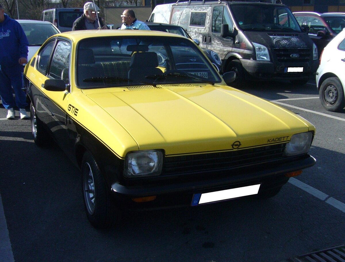 Opel Kadett C GT/E der Modelljahre 1975 bis 1977. Opel Kadett C GT/E. Der Kadett C kam 1973 auf den Markt und war als Limousine, Coupe und Kombimodell namens CarAvan lieferbar. Ab August 1975 war das Coupe als sportliches GT/E-Modell lieferbar. Das Fahrzeug war als  Basismodell  für Wettbewerbe gedacht, erfreute sich aber auch in sportlich ambitionierten Käuferkreisen größter Beliebtheit. Das Modell war nur in dieser schwarz-gelben Lackierung lieferbar. Ende des Jahres 1975 stand ein solches Coupe mit einem Kaufpreis von DM 12.950,00 in den Preislisten. Der Vierzylinderreihenmotor mit einem Hubraum von 1897 cm³ leistet mittels einer Bosch L-Jetronic Einspritzanlage 105 PS. Die Höchstgeschwindigkeit wurde mit 180 km/h angegeben. 1977 wurde das Modell GT/E durch ein optisch leicht verändertes Modell in gelb-weißer Lackierung abgelöst. Oldtimerbrunch am Cafe del sol in Gelsenkirchen am 09.03.2025.