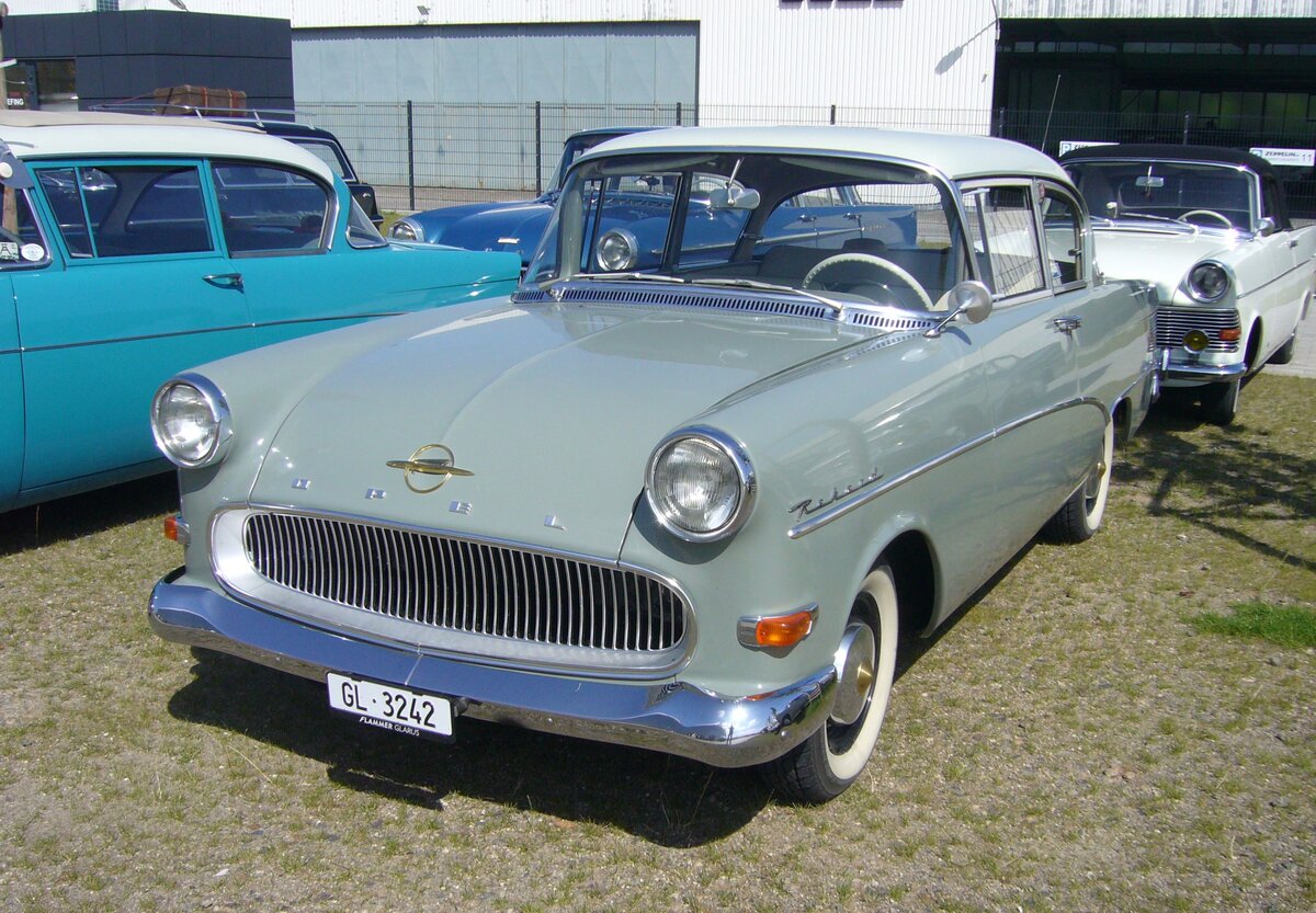 Opel Rekord P1 in der Karosserieversion zweitürige Limousine, gebaut von 1957 bis 1960. Während seiner 35-monatigen Produktionszeit, baute Opel 384.692 Limousinen (zwei- und viertürig), 109.282 Kombimodell CarAvan und 15.136 Kastenlieferwagen (ohne hintere seitliche Verglasung) von diesem Modell. Motorisiert war der P1 mit einem Vierzylinderreihenmotor mit einer Leistung von 45 PS aus einem Hubraum von 1488 cm³. Gegen einen Aufpreis von DM 75,00, konnte man einen 1.7l Motor mit 55 PS ordern. Da der P1 auch in die USA exportiert wurde und dort über das Buick-Händlernetz vertrieben wurde, erhielt er häufig den Spitznamen  Bauern-Buick . Der gezeigte P1 ist auf eigener Achse aus dem schweizerischen Kanton Glarus zum Panoramatreffen der Alt-Opel IG in Essen angereist. Beim ersten Zwischenstopp der Ausfahrt des Panoramatreffen der Alt-Opel IG am Luftschiffhangar des Flughafen Essen/Mülheim am 10.08.2024.