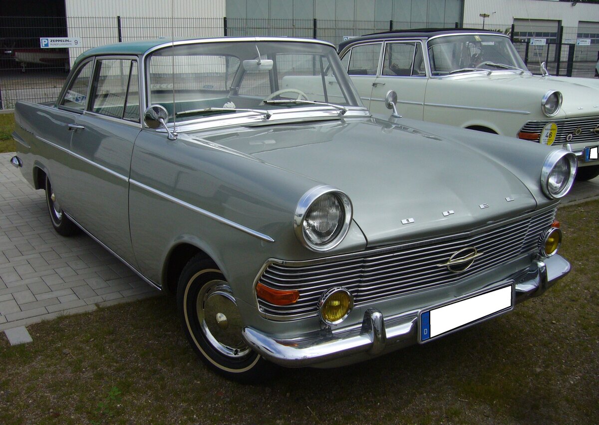 Opel Rekord P2 Coupe aus dem Jahr 1962 in der Farbkombination laplatasilber/ozeangrün. Produziert wurde das P2 Coupe von 1961 bis 1963. Während die P2 Limousine bereits im August 1960 vorgestellt wurde, folgte das Coupe genau ein Jahr später. Das Coupe war grundsätzlich mit dem stärksten Motor dieser Baureihe ausgestattet. Dieser Vierzylinderreihenmotor leistet 60 PS aus einem Hubraum von 1680 cm³. Ein solches Coupe schlug mit einem Kaufpreis von mindestens DM 7675,00 zu Buche. Beim ersten Zwischenstopp der Ausfahrt des Panoramatreffen der Alt-Opel IG am Luftschiffhangar des Flughafen Essen/Mülheim am 10.08.2024.