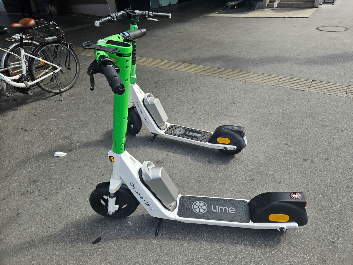 Zwei E-Scooter des Anbieters Lime, abgestellt in Innsbruck. Aufgenommen 5.8.2024.