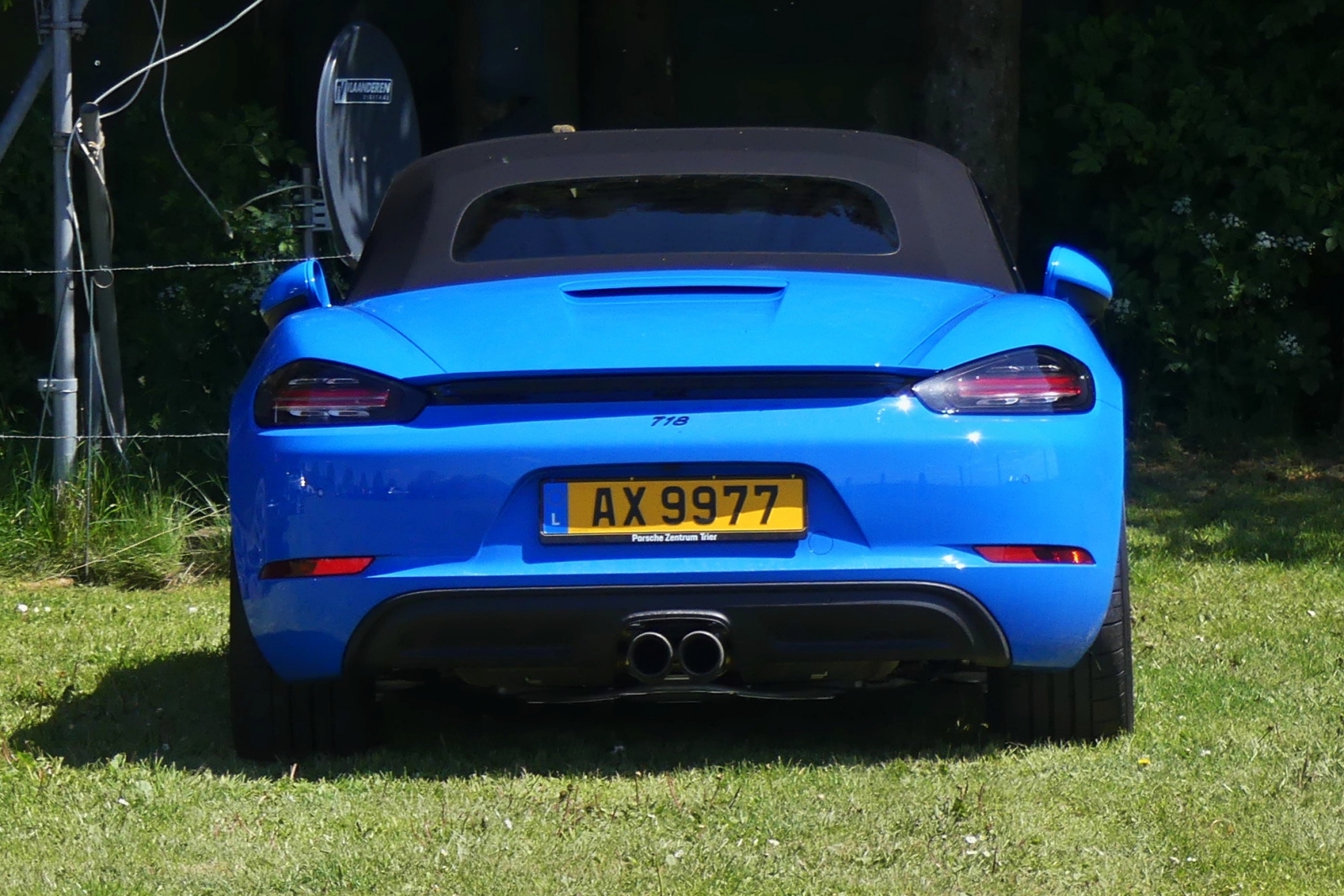 Heckansicht des Porsche 718, auf einer als Parkplatz benutztem Feld bei einer Veranstaltung. 05.2024