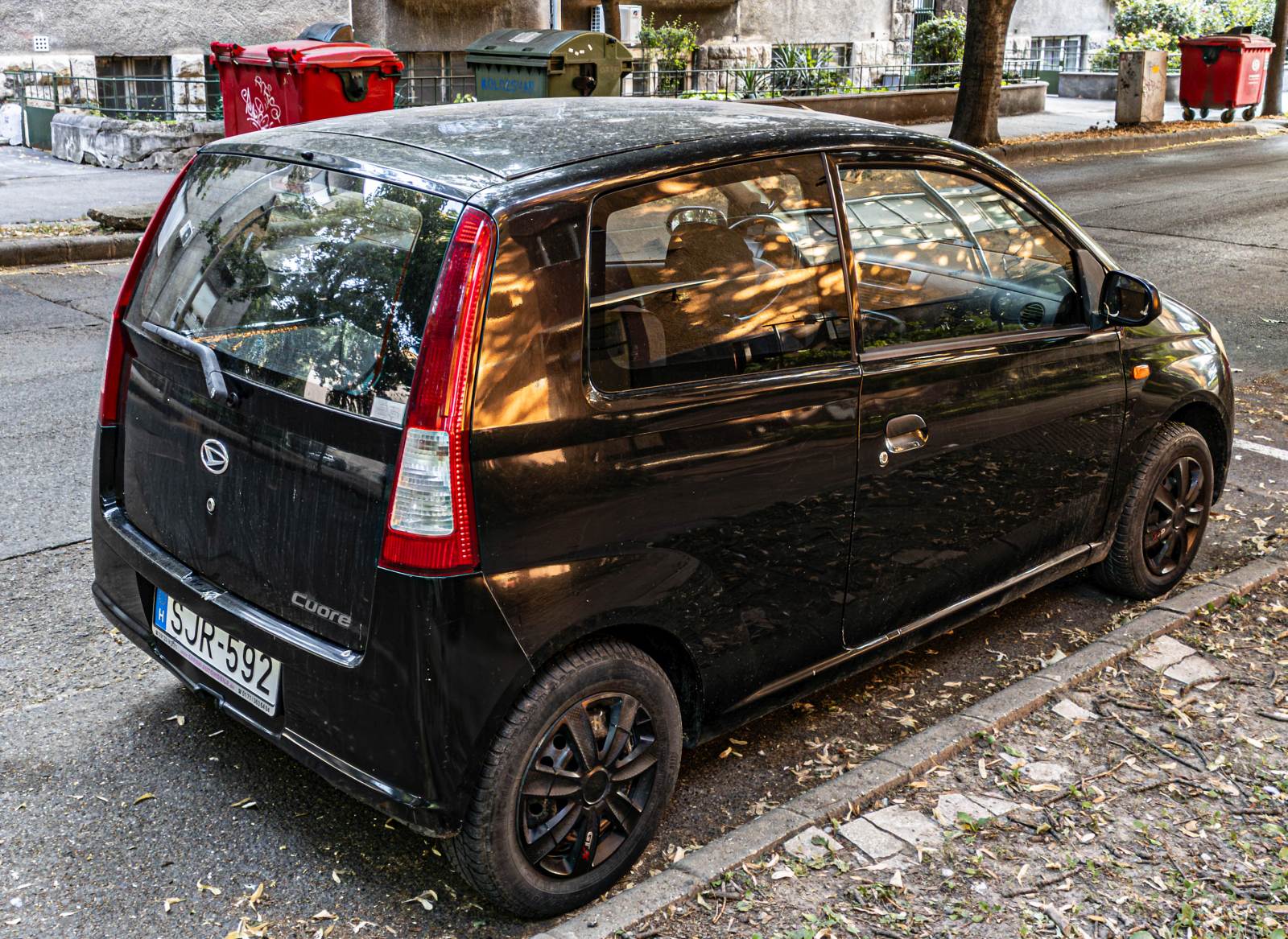 Hier ist ein dreitürerDaihatsu Cuore (siebte Generation, L2 oder L250 genannt) von hinten zu sehen. Foto: Juli, 2024.