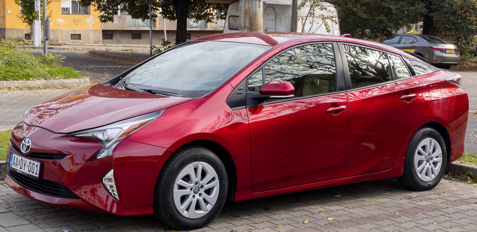 Hier ist ein Toyota Prius IV in rot Metallic (Hypersonic Red) zu sehen. Das Auto wurde aus den USA importiert und hat in Ungarn auch als Taxi gearbeitet. Foto: November, 2024.