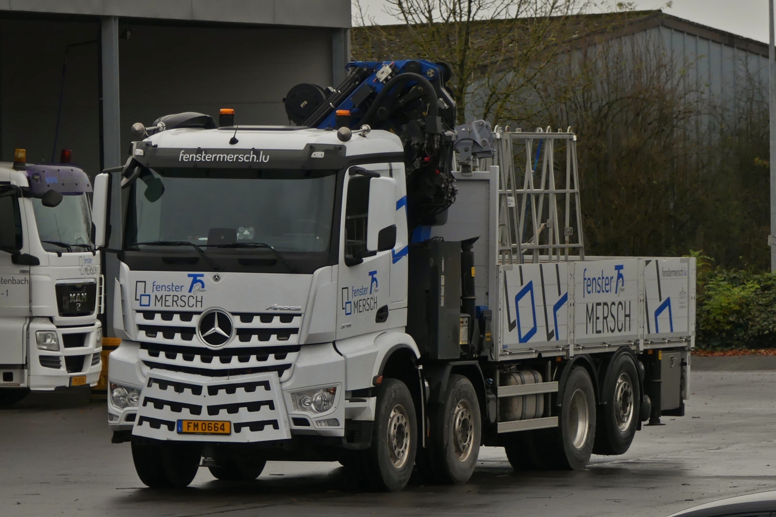 Mercedes Benz Arocs, von Fenster Mersch, steht auf deren Betriebshof, aufgenommen von der Straße aus. 11.2024