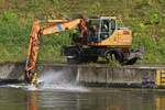 Hydraulikbagger Doosan DX 160 W, aufgenommen beim Reinigen der Kaimauer an einem Kanal.