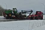 John Deere 1470E Havester wird auf einem Sattelzug zu seinem nächsten Einsatzort gebracht.