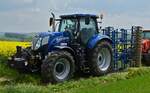 New Holland T7.210 Traktor mit Bodenlockerungsmaschine steht bereit um an der Rundfahrt durch Brachtenbach beim „Baurefest zu Brotebach“ mitzufahren.