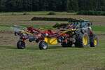 Heuernte: Pottinger Heuwender, gezogen von einem John Deere Traktor, aufgenommen bei der Auffahrt auf das Feld um das trockene Heu zu Schwaden. Feld. 08.2024