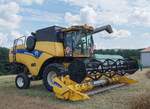 =Große Ereignisse werfen ihre Schatten voraus! Zur Vorbereitung auf die 1000 Jahr-Feier des Hünfelder Stadtteils GROßENBACH wird Weizen gebindert. Aber auch modernere Technik, hier ein New Holland CX 5090, konnte bewundert werden. 08-2024