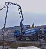 Mercedes Benz Arocs, Betonmischer mit Beton Pumpe, liefert Beton an einer Baustelle ab.