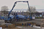 Mercedes Benz Betonmischer mit Betonpumpenaufbau und MB Sattelzug mit Betonmischer, liefern ihre Ladung an einer Baustelle an.