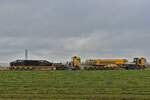 MB Schwerlastzüge, beladen mit Teilen eines Demag CC 3800-1 Raupenkrans, nahe der Baustelle einer Windkraftanlage, die im Hintergrund zu erkennen ist. 25.10.2024