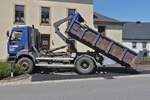 LKW Renault Absetzkipper, hat den Kipper soweit abgesenkt zum Entnehmen vom Asphalt an einer Straßenbaustelle. 06.2024