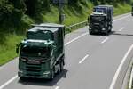 Zwei Scania mit Containeraufbau von W. Müller die am 28.6.24 unterwegs zum Trucker Festival sind auf der A8 in Matten b. Interlaken.