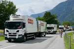 Ein Scania Hängerzug und weitere LKW von Coop die am 28.6.24 vor dem Gelände des Trucker Festivals in Bönigen stehen.