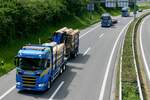 Ein Scania Holztransporter und weitere Scania von Martin Wittwer die auf dem Weg zum Trucker Festival sind am 28.6.24 auf der A8 in Matten b.