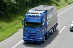 Ein Scania mit Pritscheaufbau von Rüegsegger der am 28.6.24 auf dem Weg zum Trucker Festival ist auf der A8 im Matten b.