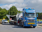 Volvo FH 16 Schwerlasttransport mit 4 Achsiger Zugmachine, beladen mit Teilen einer Windkraftanlage, bewegt sich im Krichgang durch einen Kreisverkehr im Norden von Luxemburg.