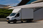 Ford Transit mit Kastenaufbau, wird an einer Baustelle entladen.