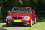 BMW 1er Cabrio, abgestellt auf einer Weide, während einer Veranstaltung. 05.2024 