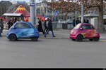 Blauer und Rosa Microlino mit Werbung unterwegs in der Stadt Zürich am 2024.12.21