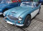 Austin Healey 3000 MK III in der Farbkombination iceblue over ivory. Der Brite Donald Healey (*1898 +1988) entwickelte dieses Modell, um insbesondere auf dem US-Roadstermarkt, erfolgreich zu sein. Der Ur-Healey wurde bereits 1951 vorgestellt und ging ein Jahr später in den Verkauf. 1968 verließ der letzte Healey die Werkshallen von Abingdon. Der Sechszylinderreihenmotor leistet im gezeigten Fahrzeug 148 PS aus einem Hubraum von 2.912 cm³. Laut der Beschreibung am Fahrzeug liegt die Höchstgeschwindigkeit dieses Roadsters aus dem Modelljahr 1964 bei 195 km/h. Oldtimer-Revival auf dem Gelände der Kokerei Zollverein in Essen am 28.07.2024.