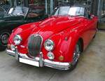 Jaguar XK150 OTS. Die Baureihe XK150 wurde 1957 als Nachfolger des XK140 vorgestellt. Anfänglich gab es ein Coupe (F ixed H ead C oupe) und ein Cabriolet (D rop H ead C oupe). Ein Jahr später wurde die Produktpalette um das besonders sportliche Modell XK150 OTS (O pen T wo S eater) erweitert. Der hier gezeigte OTS im Farbton carmen red wurde 1959 erstmalig zugelassen. Der Sechszylinderreihenmotor hat einen Hubraum von 3442 cm³ und leistet 212 PS. Classic Remise Düsseldorf am 11.01.2025.