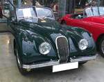 Jaguar XK120 DHC (D rop H ead C oupe) aus dem Jahr 1953 im klassischen, britischen, Farbton british racing green. Auf der London Motor Show des Jahres 1948 stellte Jaguar mit der Baureihe XK120 den Nachfolger der legendären Baureihe SS100 vor. Zuerst war das Modell als recht spartanisch ausgestatteter XK120 OTS (O pen T wo S eater) lieferbar. Ab 1953 war zusätzlich eine geschlossene Coupe-Version namens FHC (F ixed H ead Coupe) lieferbar. Das XK120 DHC ergänzte nur im Jahr 1953 die XK120 Modellpalette. Das Modell war etwas luxuriöser ausgestattet und hatte dann auch ein gefüttertes Cabriolet-Verdeck. Das Modell verkaufte sich bis zum Produktionsende der XK120-Baureihe genau 1767 mal. Der Sechszylinderreihenmotor hat einen Hubraum von 3442 cm³ und leistet in diesem Fahrzeug 160 PS. Classic Remise Düsseldorf am 11.01.2025.