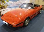 Mazda RX 7 Cabriolet. Mit dem RX 7 startete die Firma Toyo Kogyo, uns besser als Mazda bekannt im Frühjahr 1978 eine Erfolgsstory. Der avantgardistische 2+2-Sitzer mit den kultigen Klappscheinwerfern wagte Mazda einen Neustart für Fahrzeuge mit Wankelmotor. Der flach gebaute RX 7 war ganz auf den kompakt bauenden Zwei-Scheiben-Kreiskolben-Motor zugeschnitten. Den Reiz des Besonderen bekam der RX 7 auf dem deutschen Markt aber auch als erstes Cabriolet mit Kreiskolben-Motor. Diesen Traum vieler Frischluftfans verwirklichte der Essener Mazda-Händler KüWe. Der gezeigte Wagen dürfte aus den Jahren 1981 bis 1983 stammen, denn nur in diesem Zeitraum wurden die kultigen Rotary-Felgen verbaut. Die beiden Wankelkammern haben jeweils einen Inhalt von 573 cm³ mit einer Gesamtleistung von 115 PS. Techno Classica Essen am 05.04.2024.