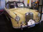 Mercedes Benz W180/2 220S Cabriolet. Dieses Modell war von 1956 bis 1959 im Verkaufsprogramm von Mercedes Benz. Das gezeigte Cabriolet in der Bicolor-Lackierung tabakbraun/beige wurde erstmalig im Juli 1956 in den USA zugelassen. Ein solches Cabriolet kostete, bei einem Kaufpreis von DM 21500,00, fast doppelt so viel, wie die Limousine, die mit DM 12.500,00 in der Preisliste von Mercedes Benz stand. Der Mehrpreis für das Cabriolet hätte für den Erwerb von zwei VW Käfern gereicht. Der von einem Solex-Registervergaser  befeuerte  Sechszylinderreihenmotor hat einen Hubraum von 2195 cm³ und leistet 100 PS. Essen Motor Show am 04.12.2024.