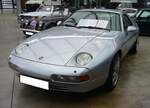 Porsche 928GTS aus dem Jahr 1993. Bei der Konstruktion des ab 1978 produzierten 928 stand der Leichtbau im Vordergrund. So wurden die Türen, die vorderen Kotflügel sowie die Motorhaube aus Aluminium statt aus Stahlblech gefertigt. Der 928 hat runde, in die Kotflügel integrierte Hauptscheinwerfer, die elektrisch hochklappbar sind. Das abgerundete Fließheck wird von der großen Scheibe der Heckklappe dominiert. Der gezeigte 928 GTS im Farbton polarsilber, war die letzte Entwicklungsstufe dieser Baureihe. Er hat verbreiterte hintere Kotflügel, ein rotes Leuchtenband am Heck, einen in Wagenfarbe lackierten Heckflügel, Außenspiegel im Cup-Design sowie serienmäßig 17-Zoll Cup-Felgen, die bei diesem Fahrzeug aber wohl ausgetauscht wurden. Der V8-Motor hat einen Hubraum von 5397 cm³ und leistet 350 PS. Die Zuffenhausener gaben die Höchstgeschwindigkeit mit 275 km/h an. Bei seinem Verkaufsstart im Jahr 1992 betrug der Basispreis für einen solchen 928 GTS DM 85.840,00. Classic Remise Düsseldorf am 01.11.2024.